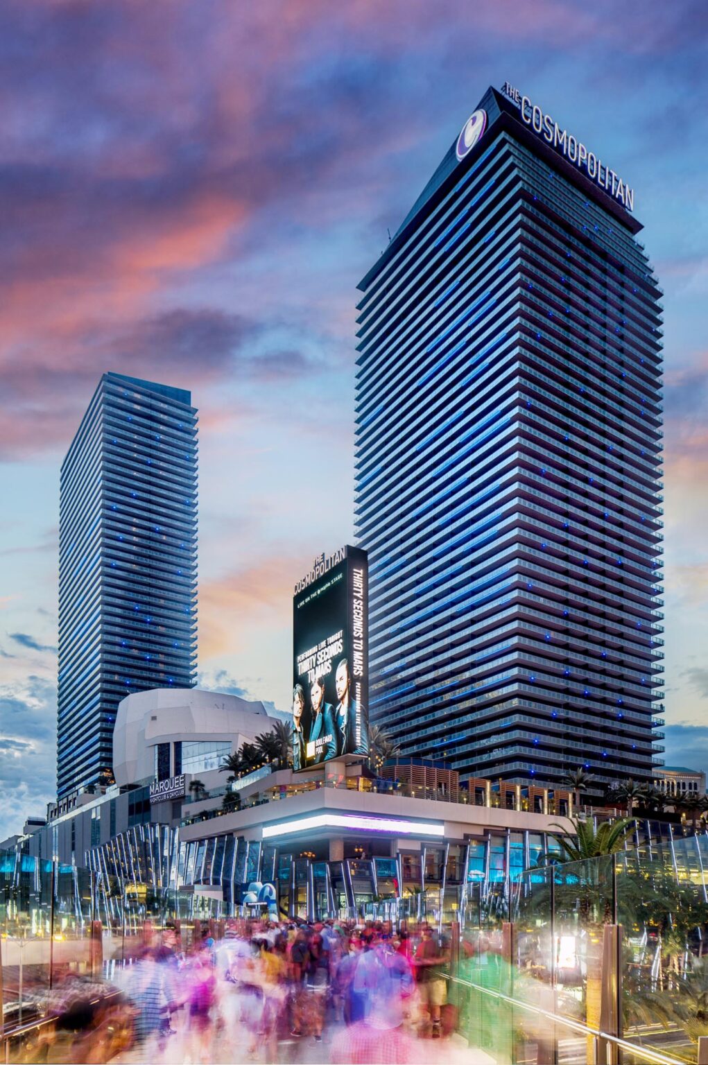 The Cosmopolitan of Las Vegas Exterior of two hotel towers on the Las Vegas strip and a crowd crossing the bridge leading to the hotel